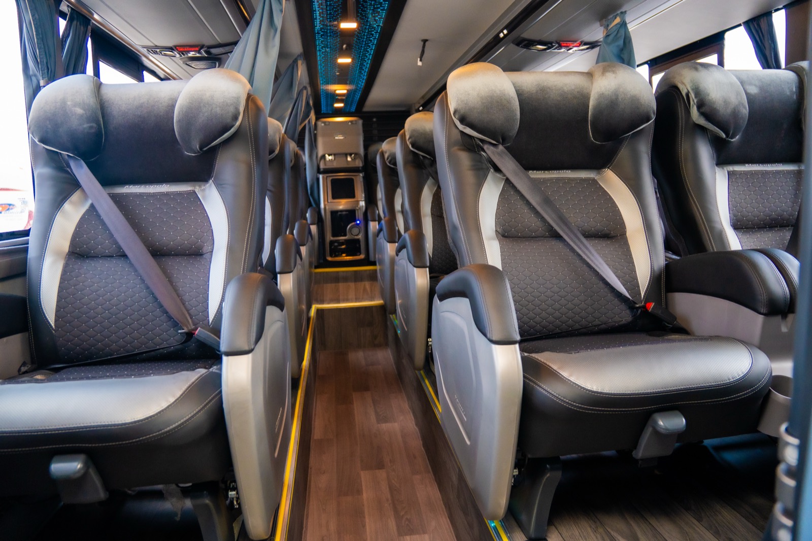 Pasillo interior de un bus Salón Cama de Nar Bus con dos hileras de asientos reclinables